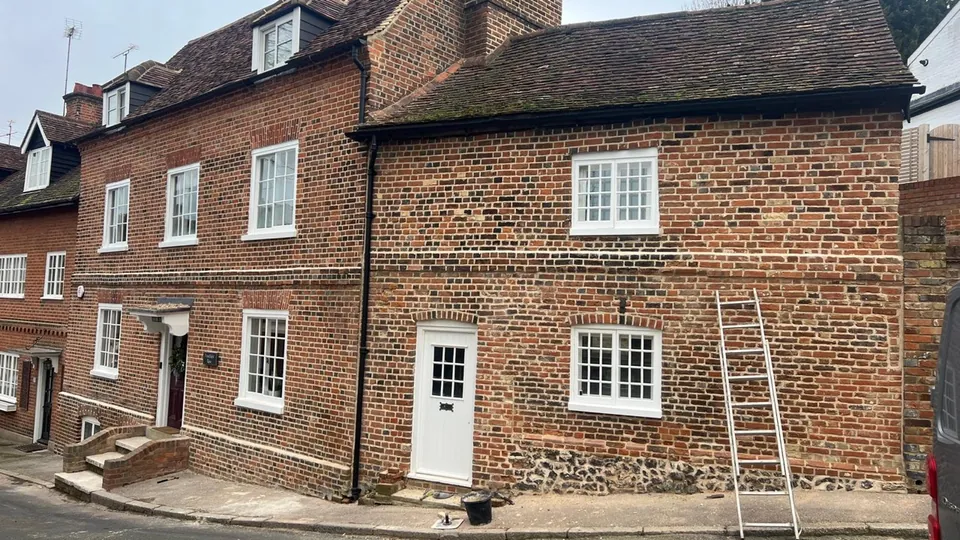 Row of period red brick cottages after masonry repairs and repointing