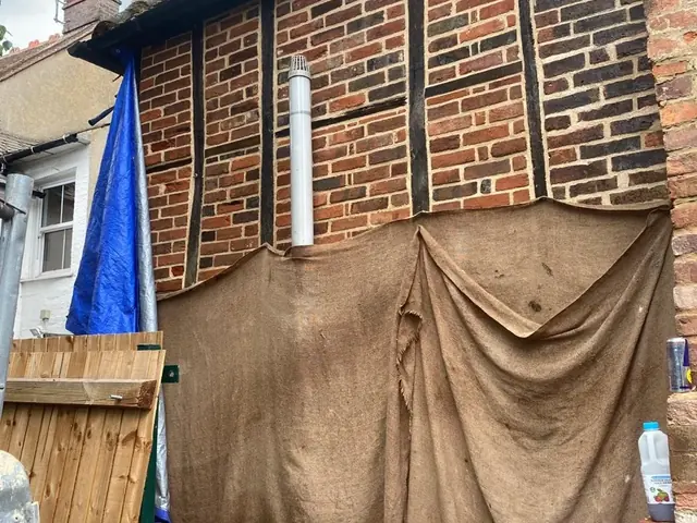 Exposed timber framing and damaged brick infill during restoration.