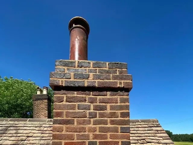 Completed chimney stack with new pointing and a terracotta pot.