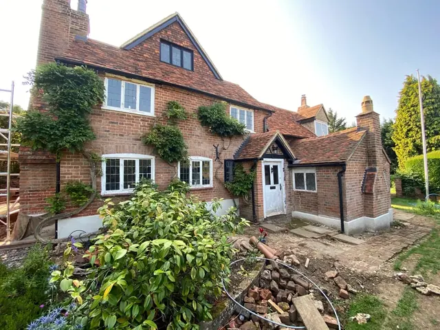 Period brick house and rear extension during ground and masonry work.