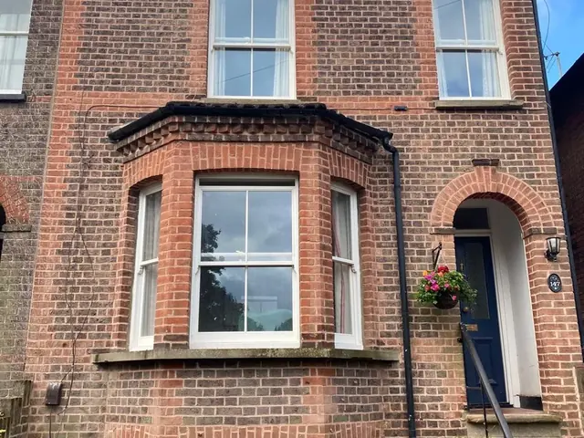 Repointed Victorian brick house with a bay window and arched entrance, shown as a full front elevation.