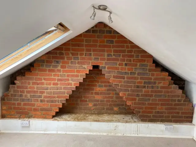 Exposed brick loft wall with stepped edges where plaster has been removed.