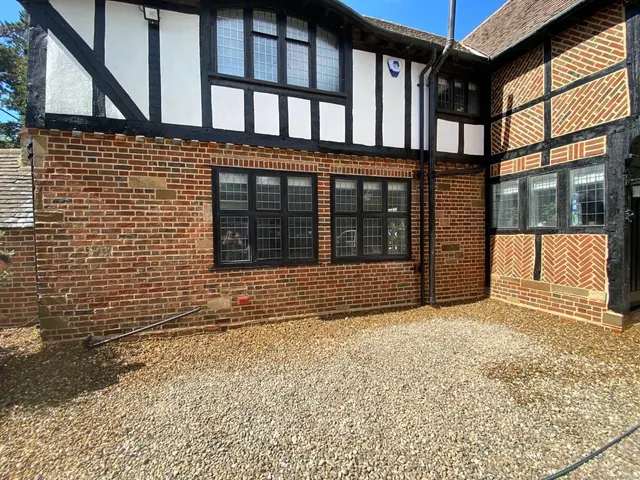 Restored timber framed courtyard wall with renewed brick infill and pointing.