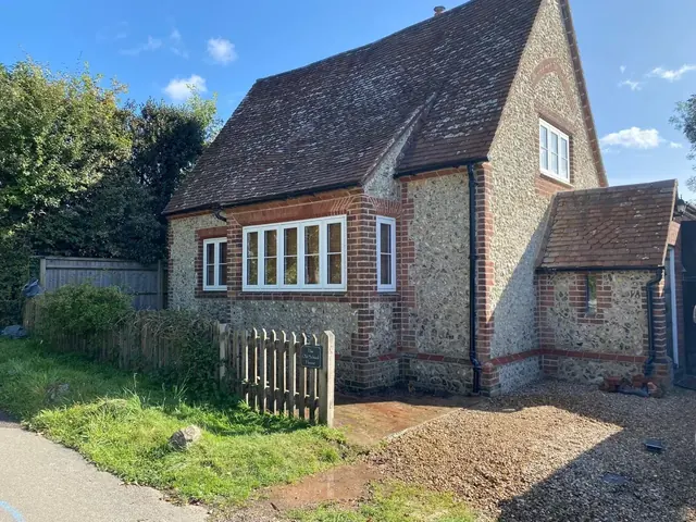 Flint and brick cottage after exterior masonry restoration.