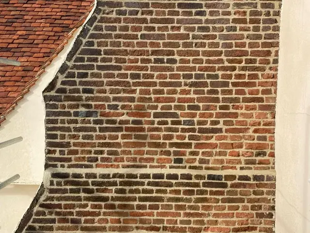 Red brick gable elevation with fresh mortar joints after repointing.