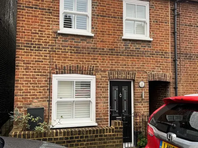 Terraced red brick house viewed before repointing.