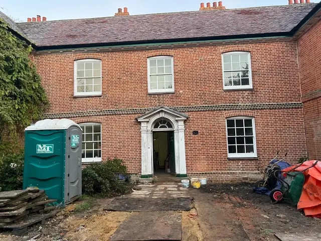 Restored red brick period building with a renewed facade and cleaned courtyard.