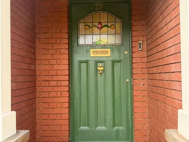 Repointed entrance porch around a green door before final clean down.