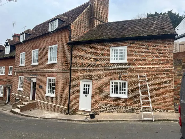 Row of period brick cottages after repointing and masonry repairs.