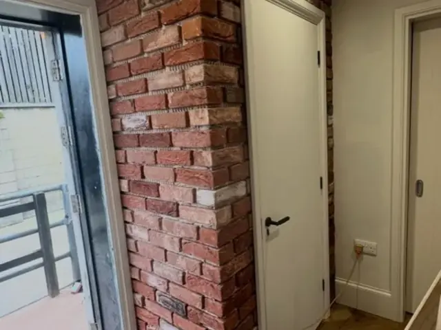 Exposed brick column beside an internal doorway during refurbishment.