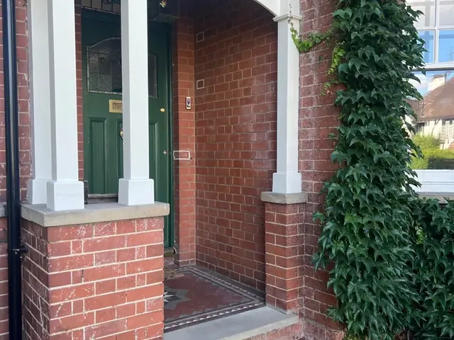 Completed entrance porch with restored brickwork and painted timber details.