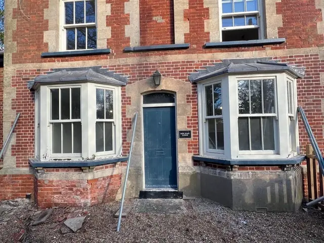 Front elevation of a period lodge during brick repair and repointing.